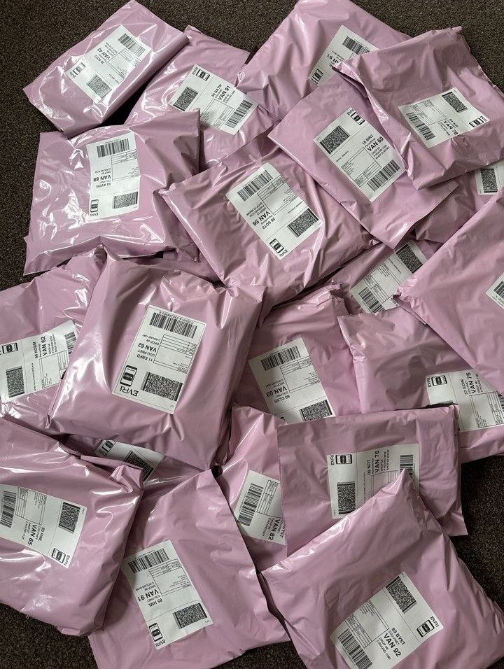 Past Gems orders packed in pink mailers, ready to post