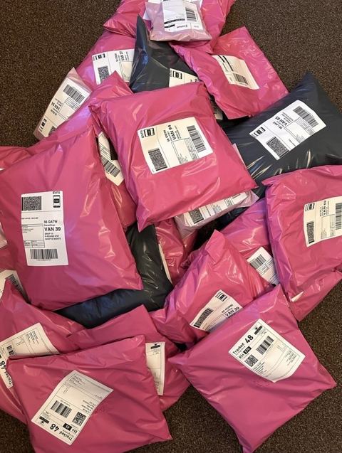 Past Gems parcels in pink mailers, ready to post